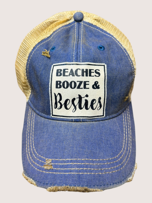 Blue denim cap with yellow mesh back and 'Beaches Booze & Besties' text on a light gray background