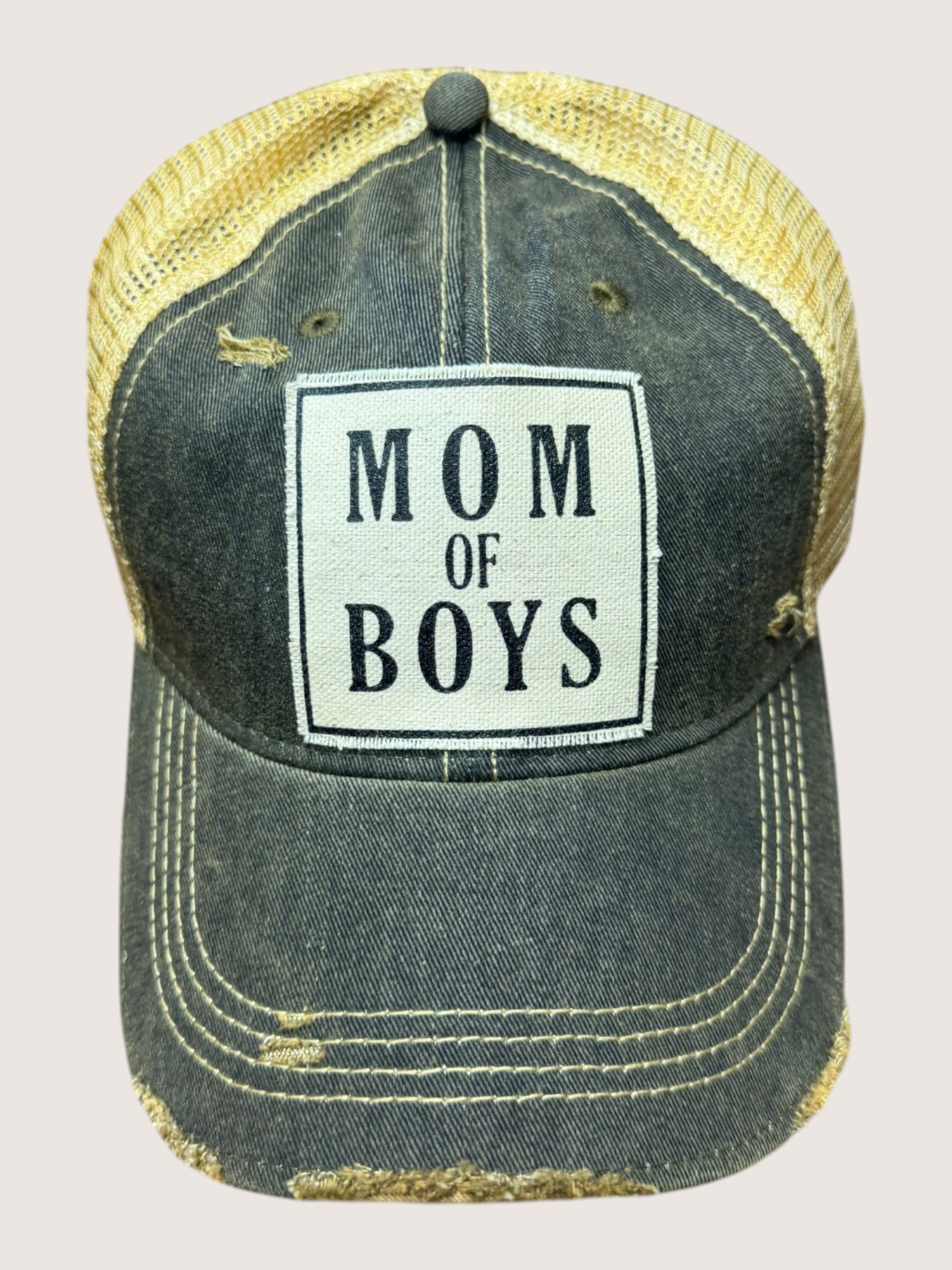 Distressed cap with 'Mom of Boys' text on a beige background
