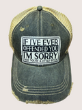 Black and gold cap with a humorous text patch on a light gray background