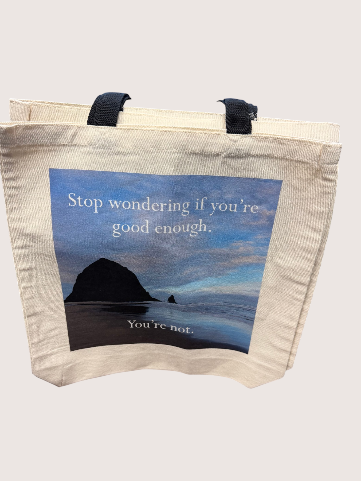 Tote bag with scenic design and motivational quote on a plain background