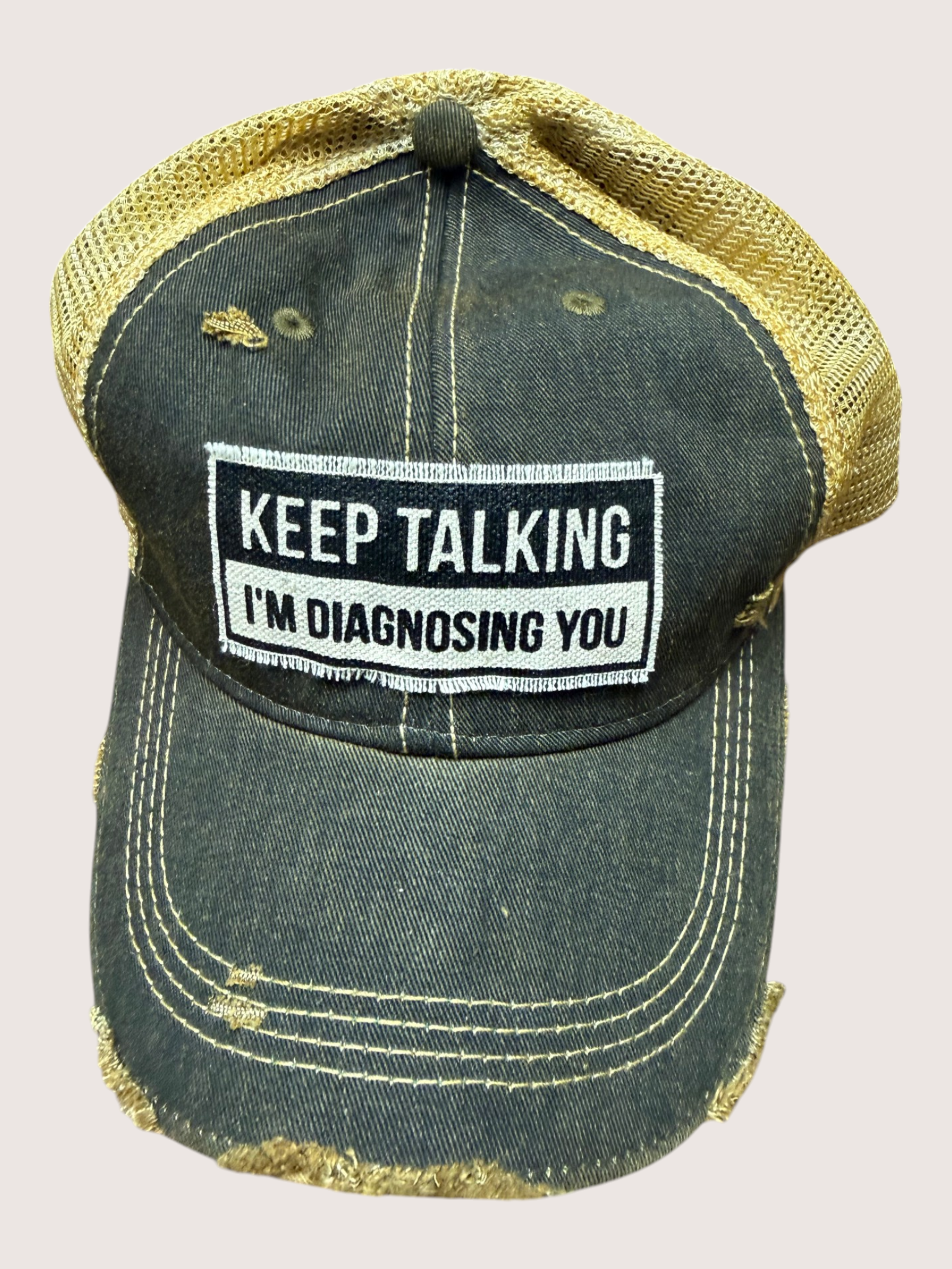 Vintage-style cap with a patch reading 'Keep Talking I'm Diagnosing You' on a light pink background