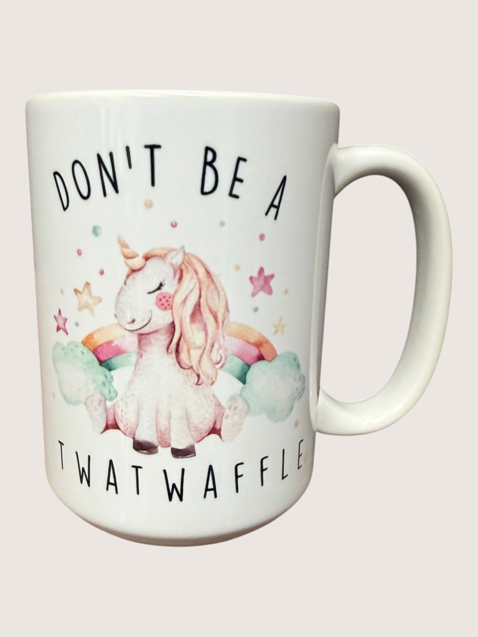 Mug with a unicorn illustration and text on a light pink background