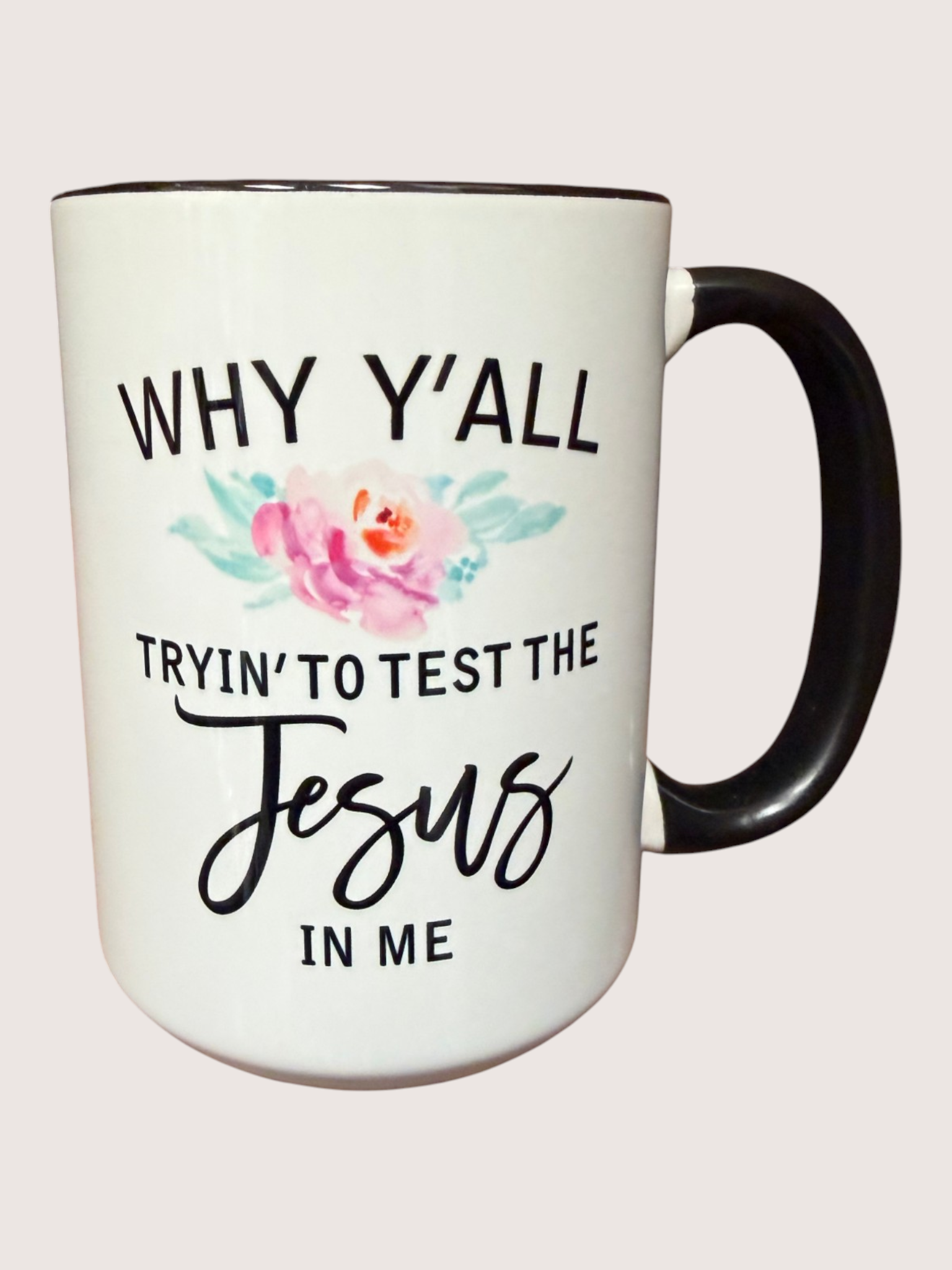 White mug with black text and floral design on a white background
