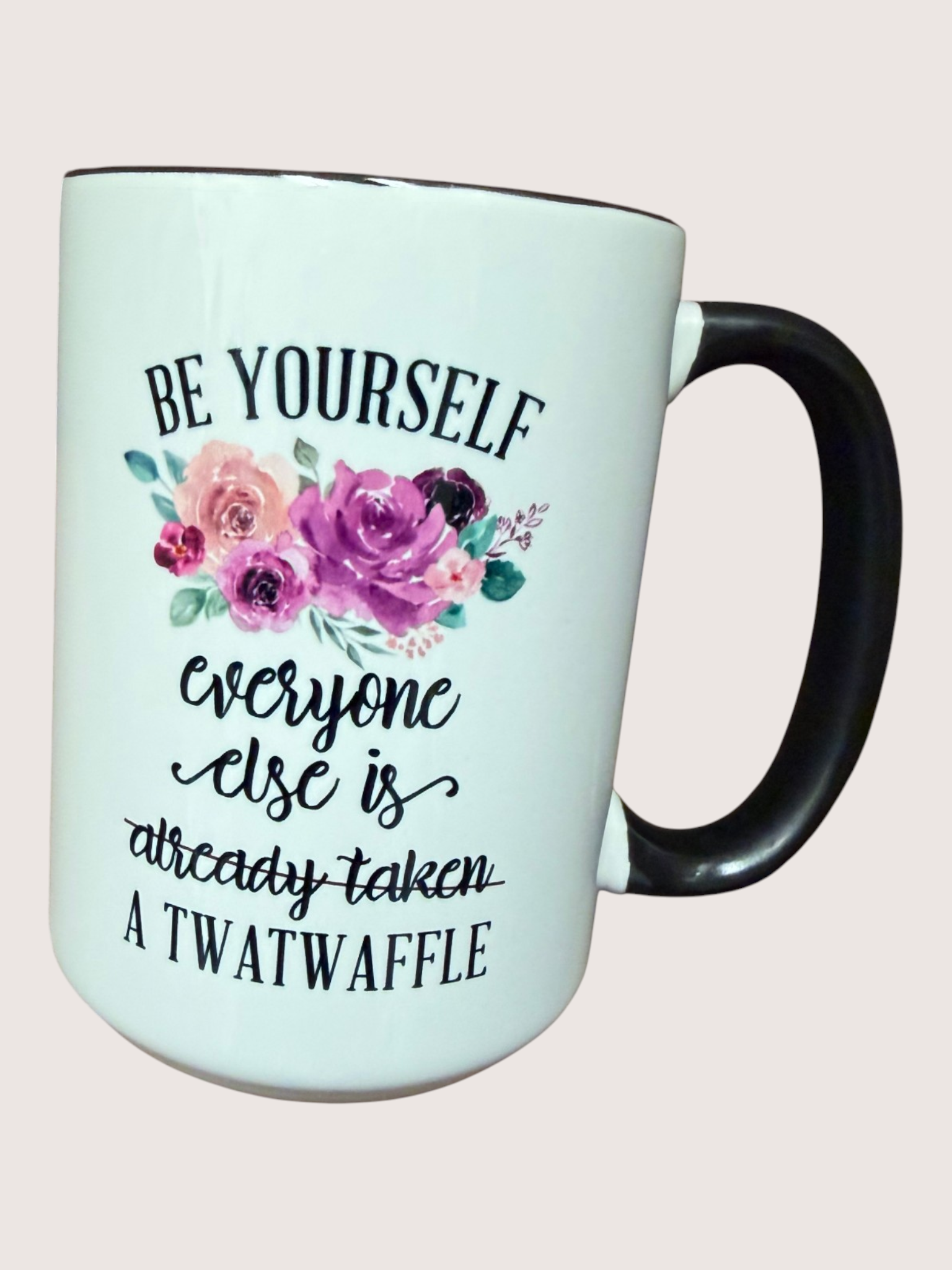 Mug with floral design and text on a light pink background