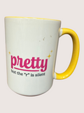 White mug with yellow handle and pink text on a white background