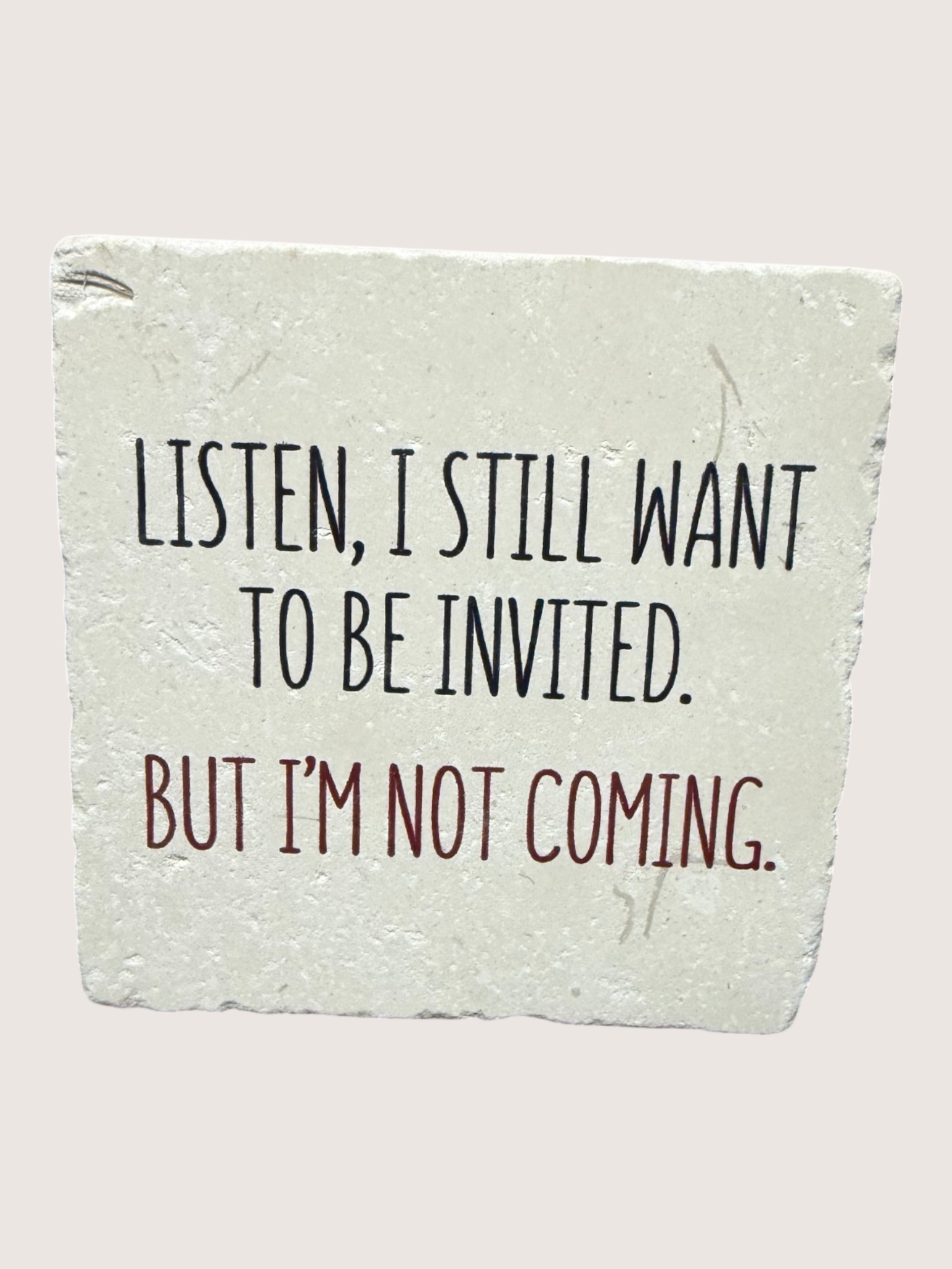 coaster with Text on a stone surface saying 'Listen, I still want to be invited. But I'm not coming.'