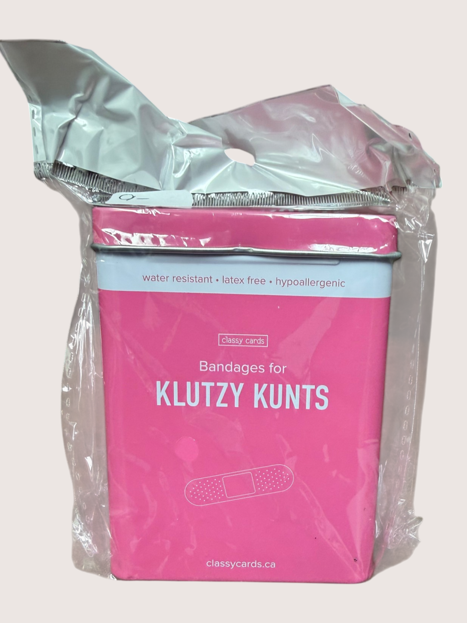 Pink packaging of bandages with text on a light gray background