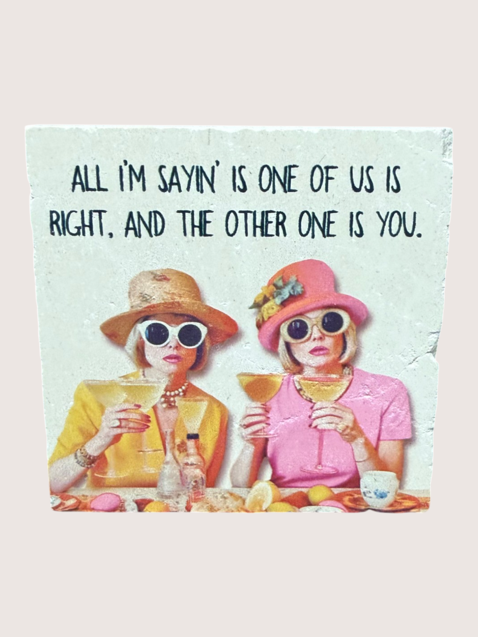 coaster Two women sitting at a table with drinks, wearing hats and sunglasses, with a quote above them.