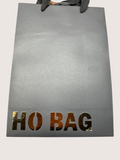 black gift bag with 'HOBAG' branding on a light gray background