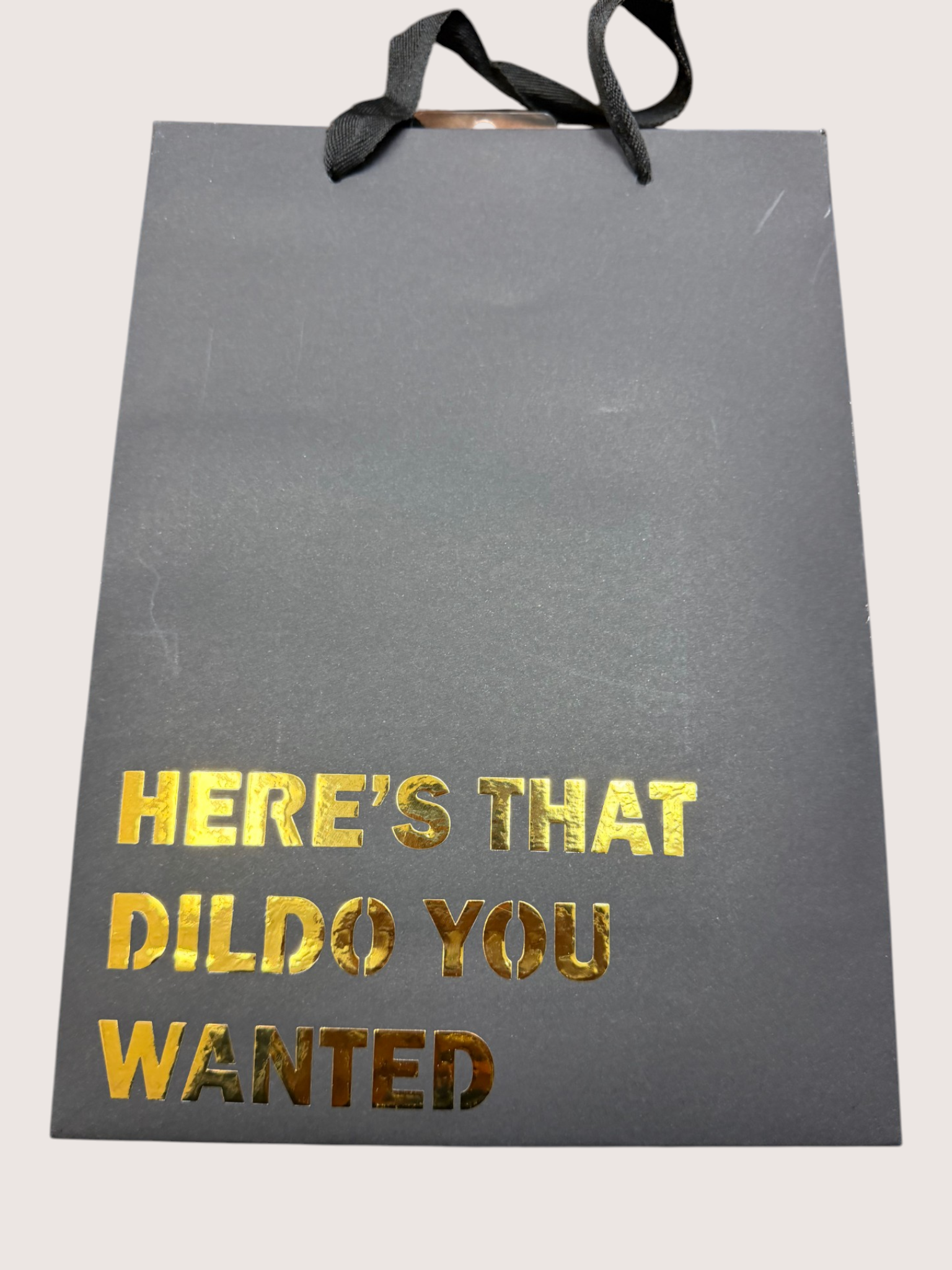 Black gift bag with gold text on a white background