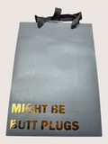 black gift bag with gold and brown text on a light gray background