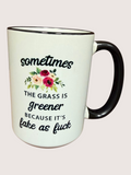 White mug with black handle featuring a floral design and text on a white background