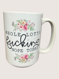 White mug with floral designs and text on a light pink background