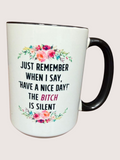 White mug with black handle featuring a floral design and text on a light pink background