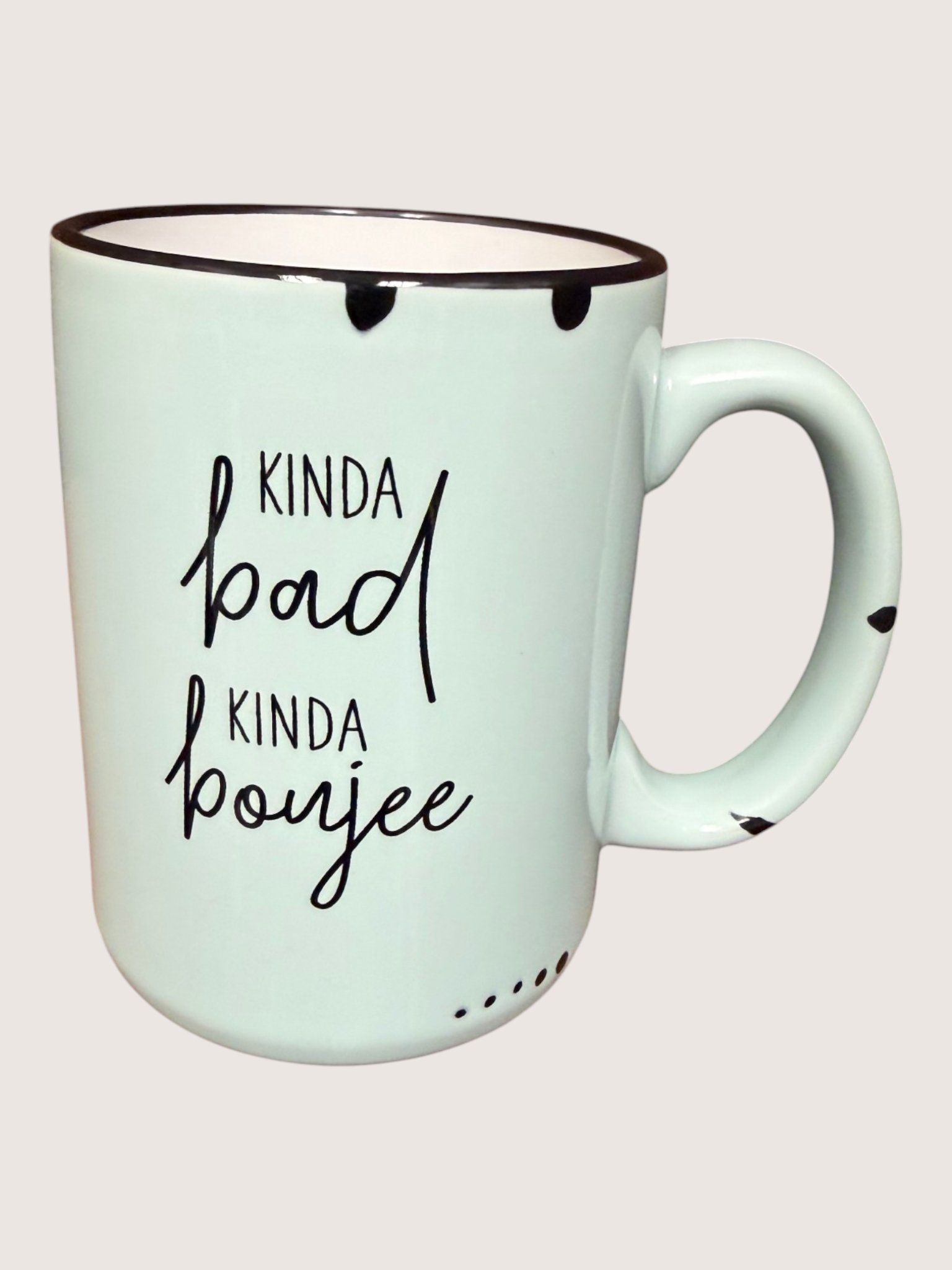 Mint green mug with black text on a light pink background