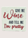 Motivational coaster with 'Give me wine and tell me I'm pretty' text on a light background