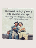 Two women sitting on a bench with a humorous age-related quote above them.