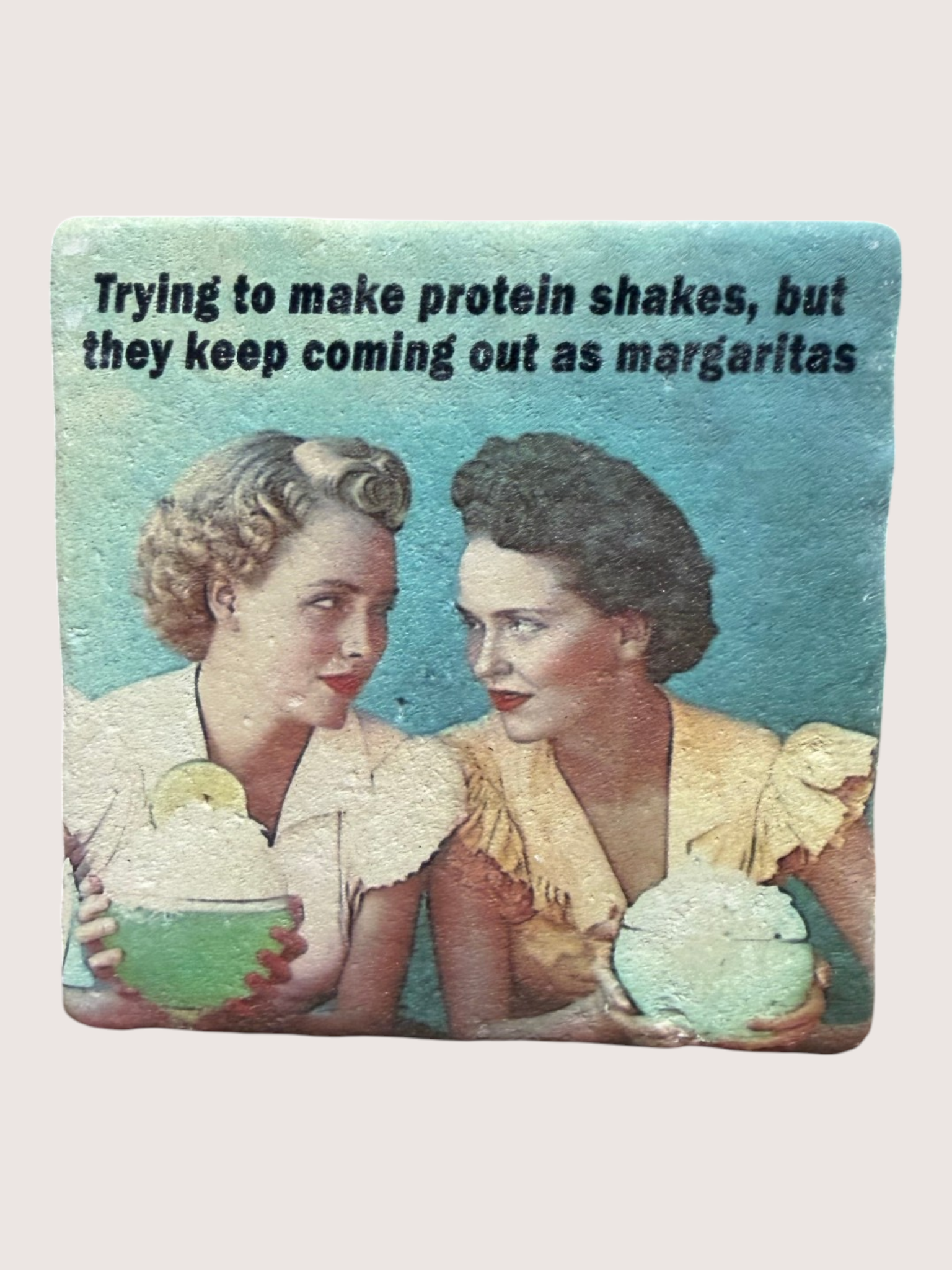 Vintage-style coaster with two women holding protein shakes and a humorous text overlay.