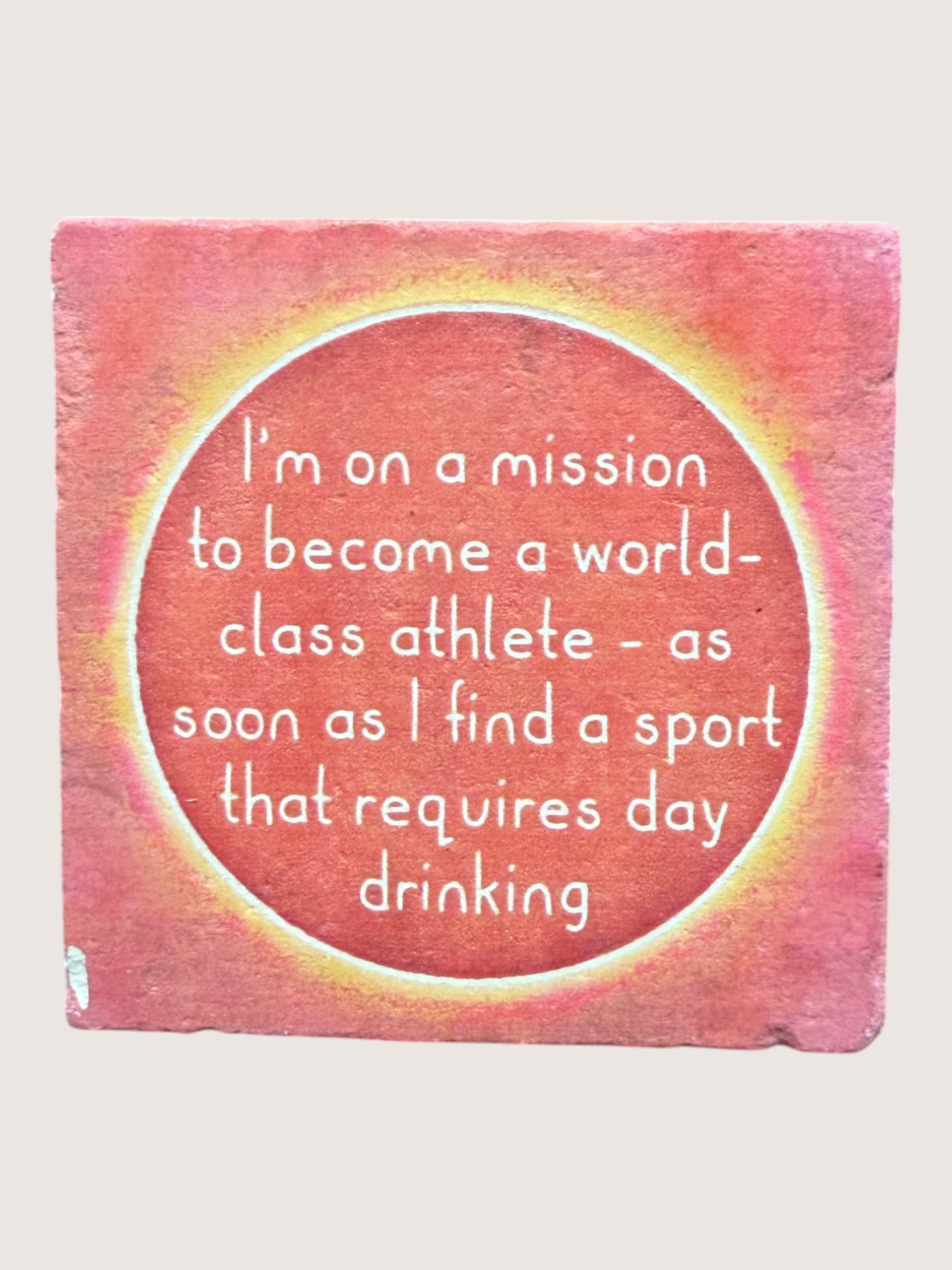 Pink coaster with humorous text on a white background
