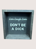 Decorative box with text 'Live, Laugh, Love DON'T BE A DICK' on a light gray background